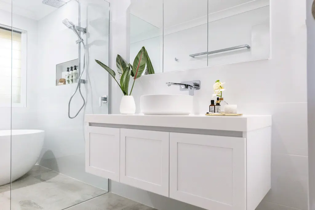 Modern white bathroom with floating vanity, vessel sink, and glass shower