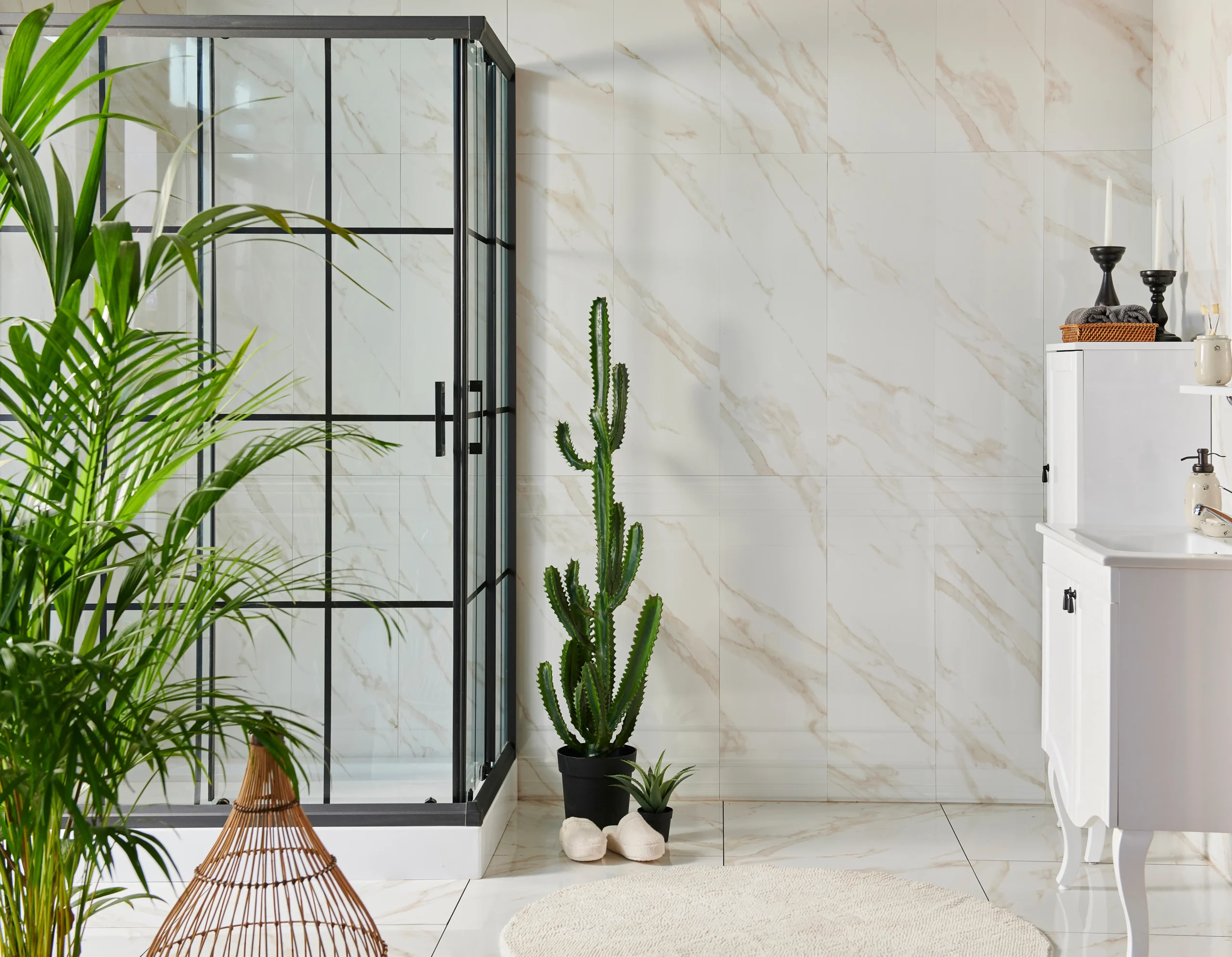 Modern bathroom with glass shower enclosure, marble tile walls, white vanity, and indoor plants