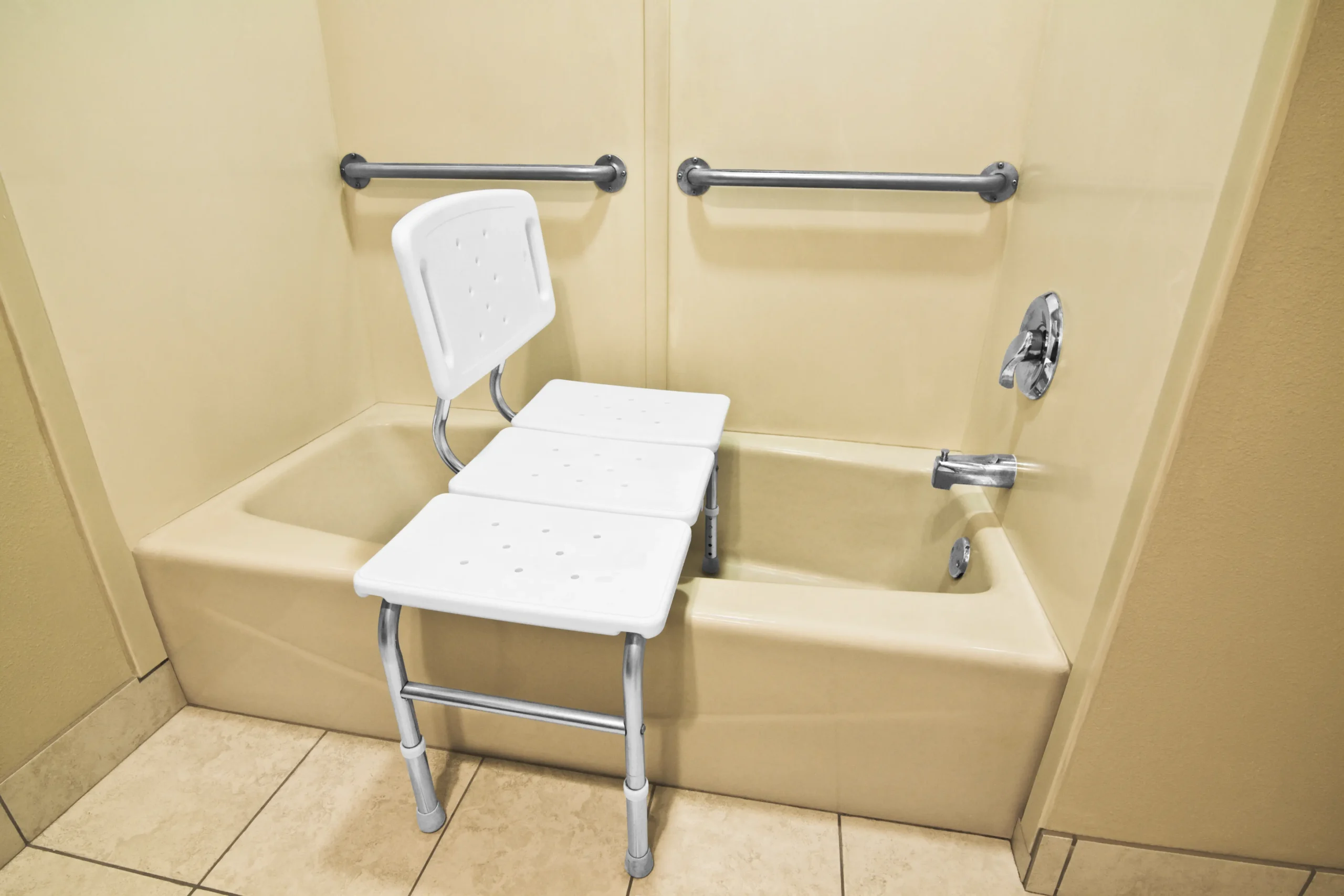 Tub transfer bench with grab bars installed in a beige bathtub