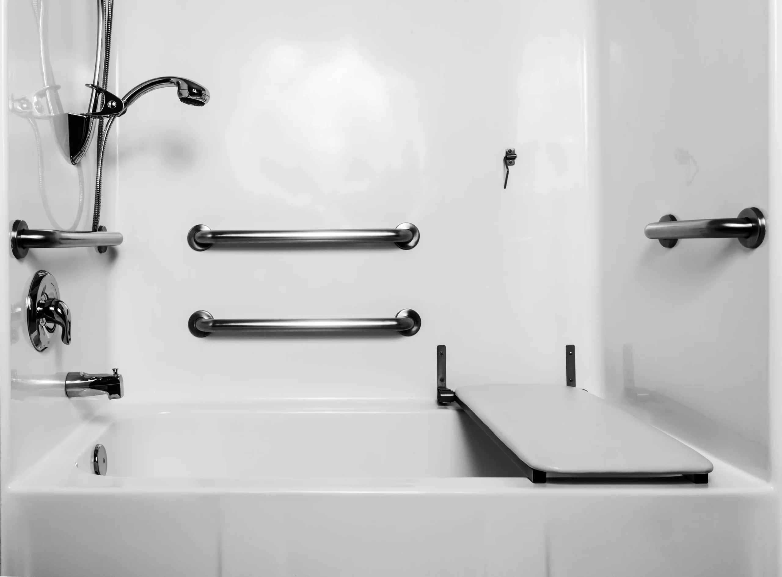 Accessible bathtub with grab bars, handheld showerhead, and transfer bench