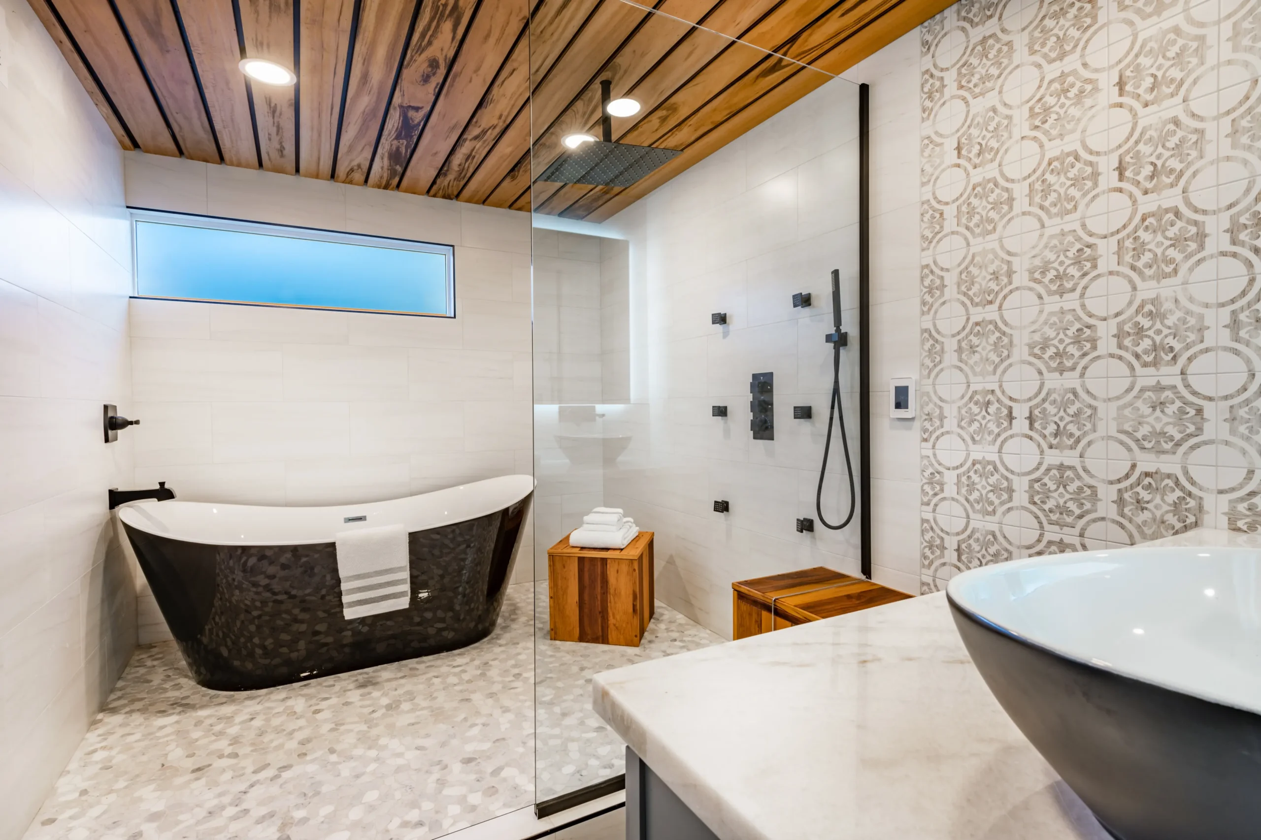Luxury bathroom with black freestanding tub, wood ceiling, and walk-in shower