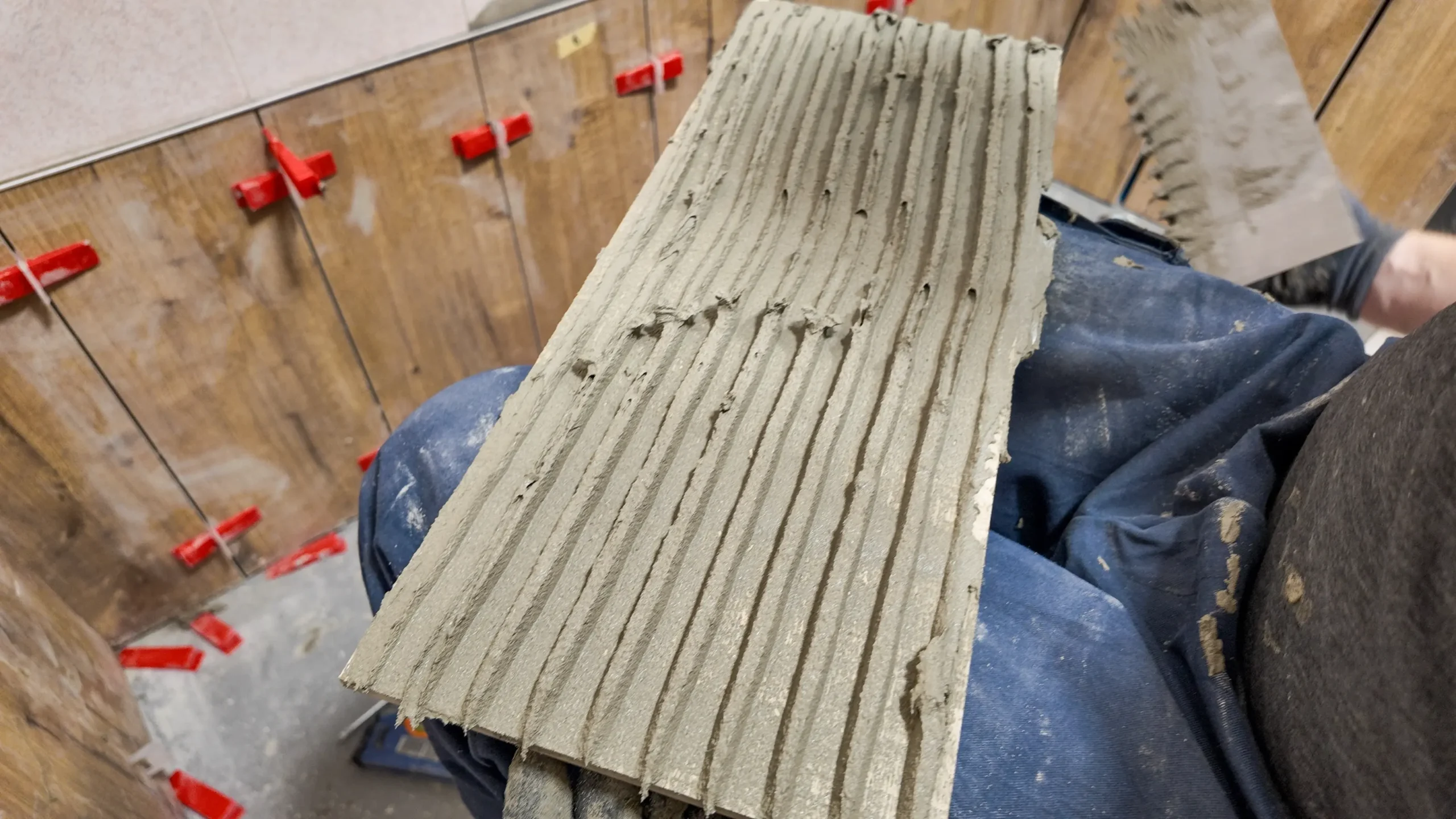 Tile with freshly combed mortar ready for wall installation