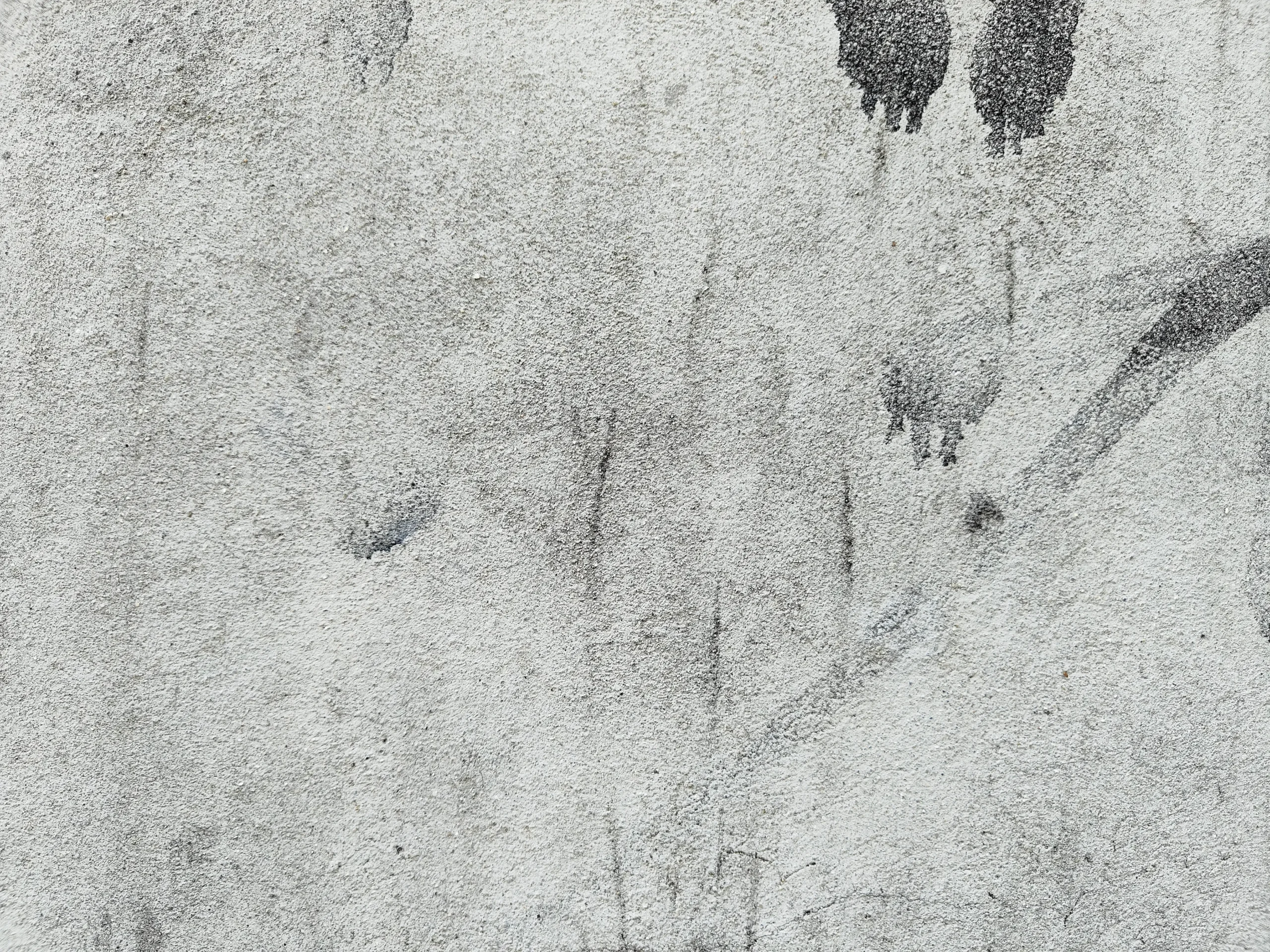 Stained gray concrete wall with visible water marks and wear